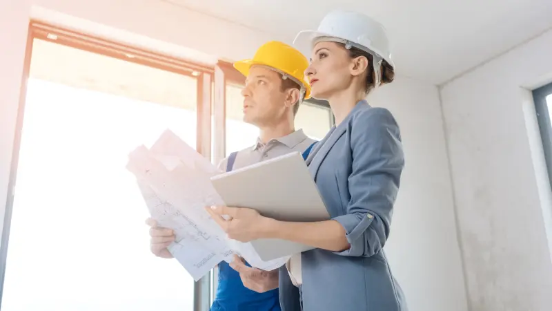 haus-endabnahme-checkliste-maengel Bauherr mit Checkliste bei der Endabnahme, um die fertigen Arbeiten auf Mängel zu prüfen.